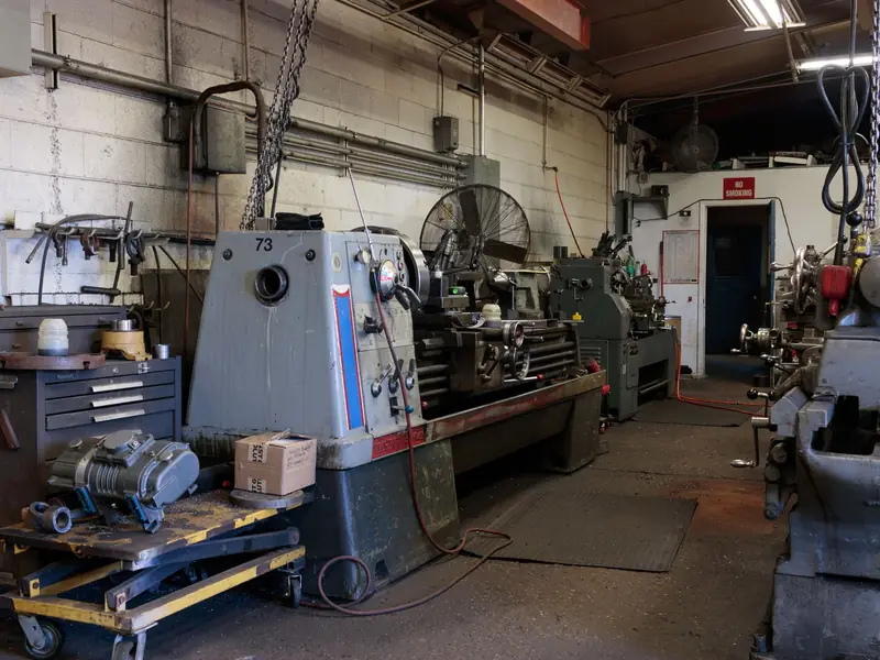 Engineering workshop with a large lathe and tool chests along the wall